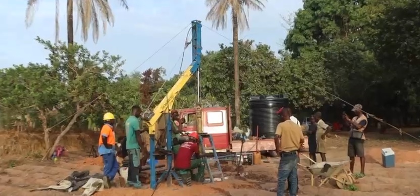 Drilling rig and crew at a village site